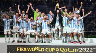 在卡塔尔战胜法国队后，莱昂内尔·梅西和他的队友们捧着2022年世界杯的奖杯庆祝。