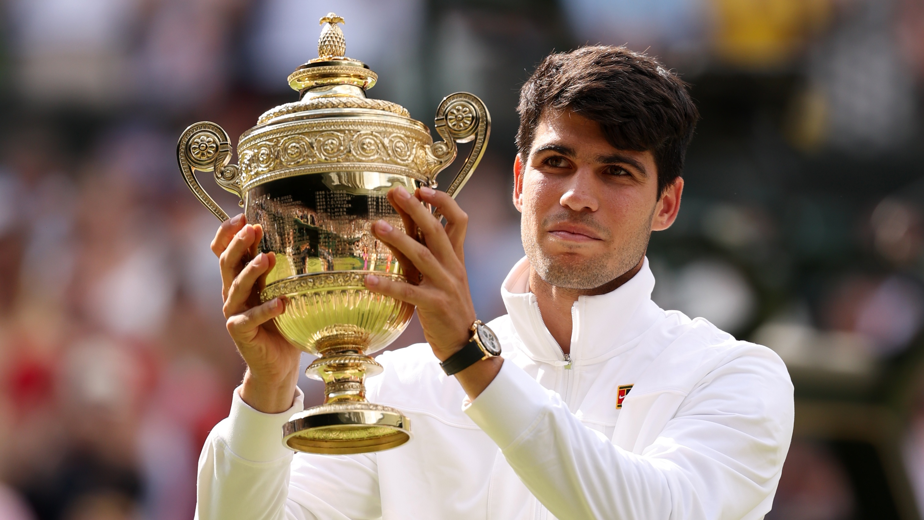 Carlos Alcaraz holds the Wimbledon Men&#039;s trophy aloft after his 2024 success.