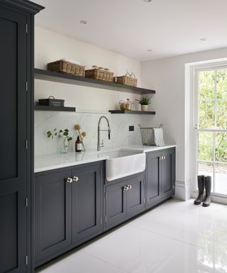 navy units in boot room with white butler sink and white tiled floor