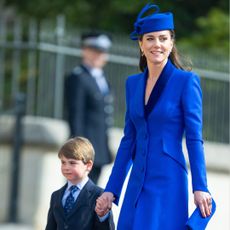Princess Kate wearing a cobalt blue coat holding hands with Prince Louis on Easter 