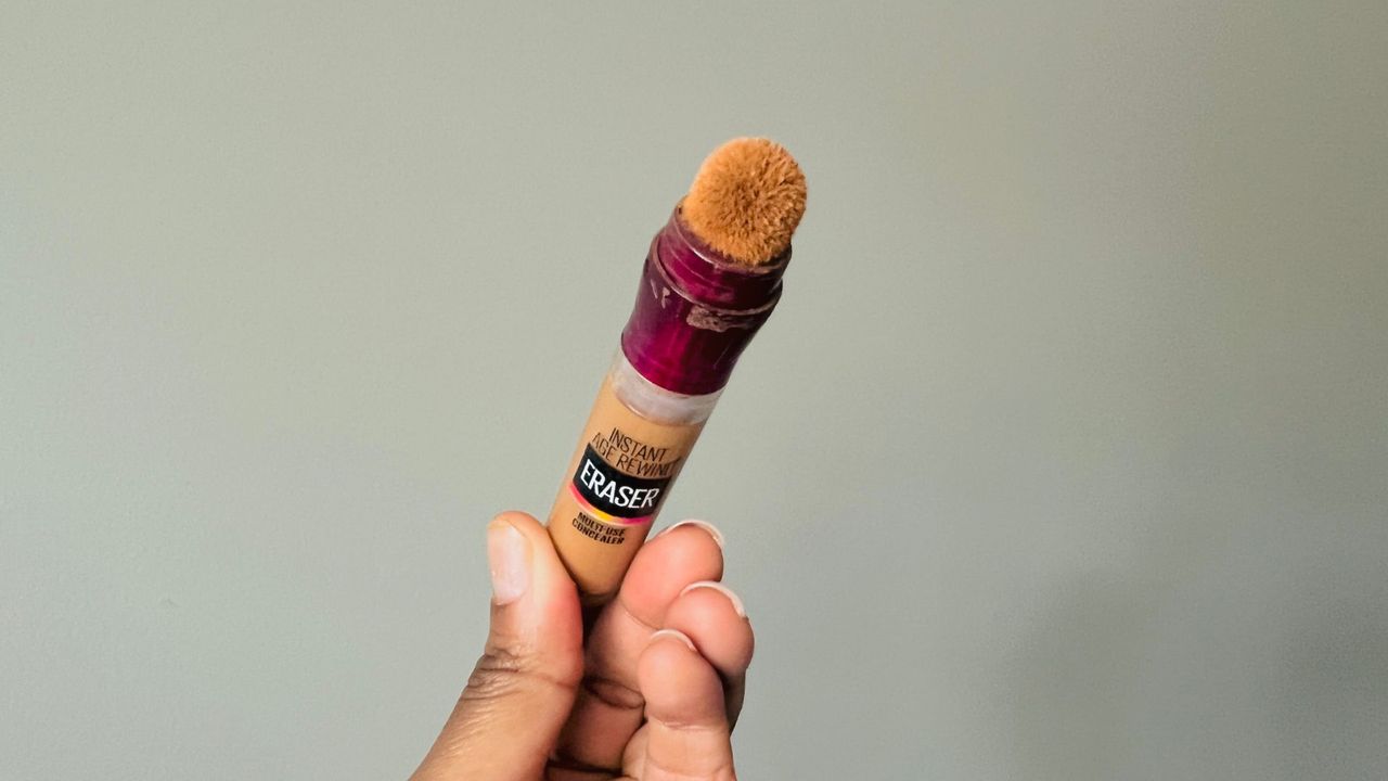 A person holding the Maybelline Instant Age Rewind Eraser Concealer for the best drugstore concealers.