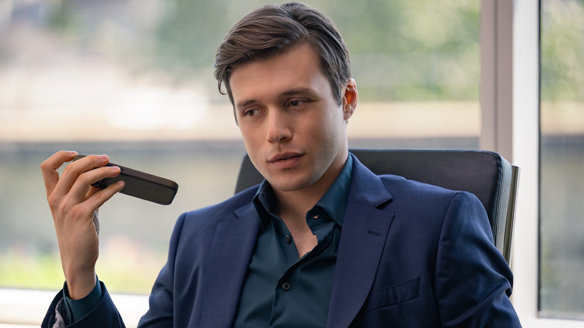 Nick Robinson holding up a phone with his left hand.
