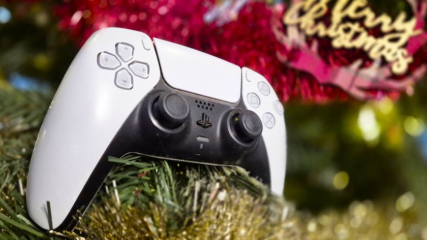 Photo of a white DualSense controller sitting on the branch of a Christmas tree.