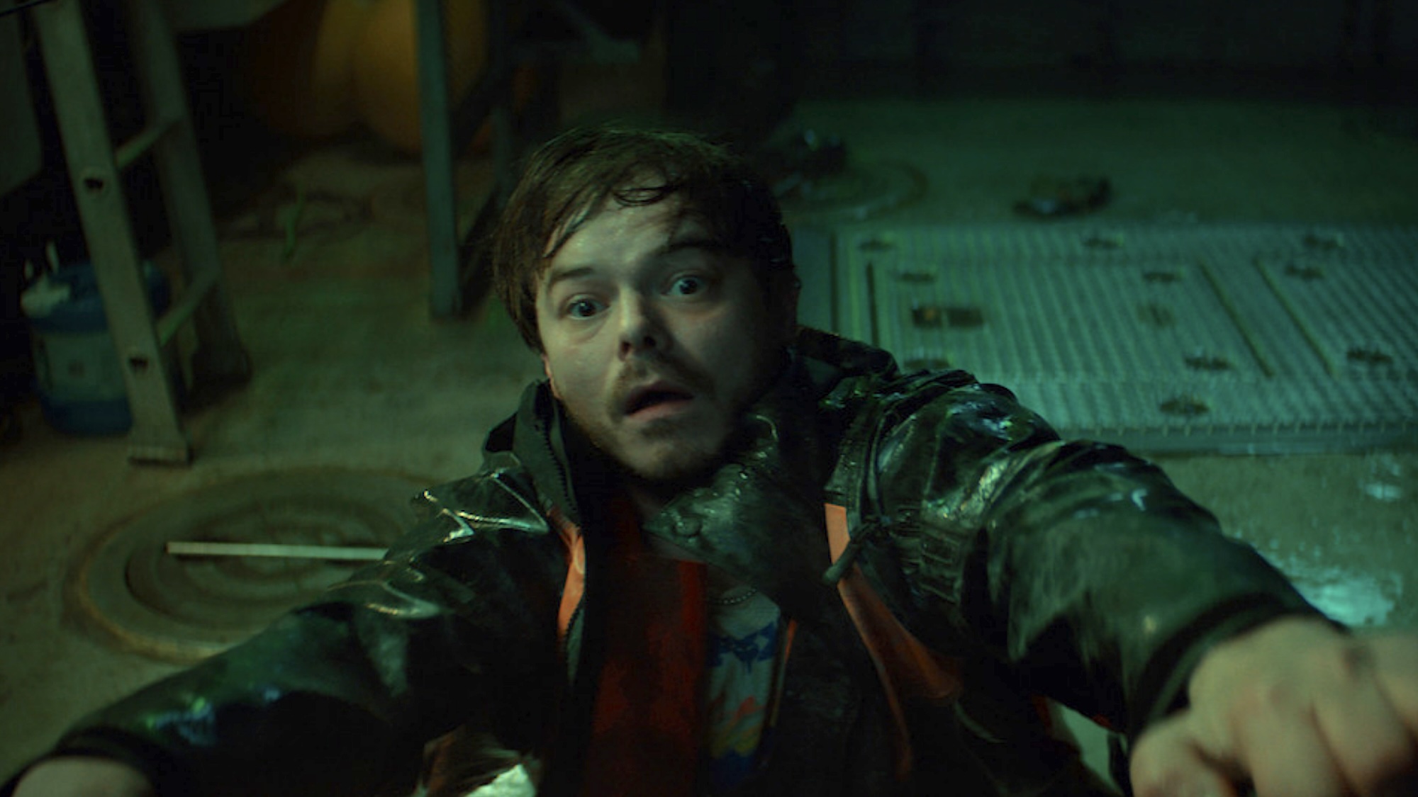 Wade Penney staring up afraid while hanging off of something in Netflix's Below