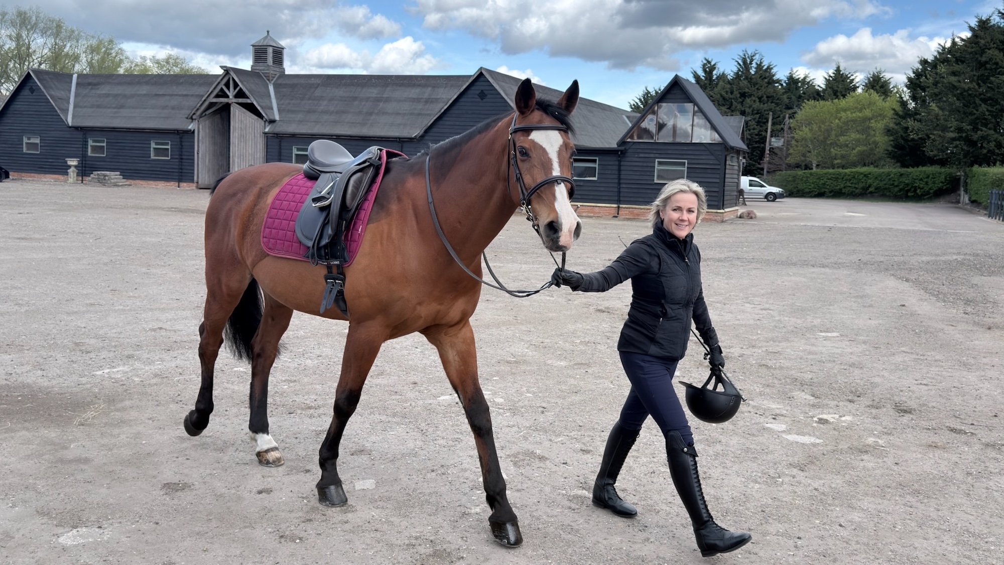Jojo Moyes walks her horse across the yard at equestrian centre