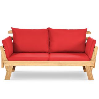 A patio daybed with red cushions