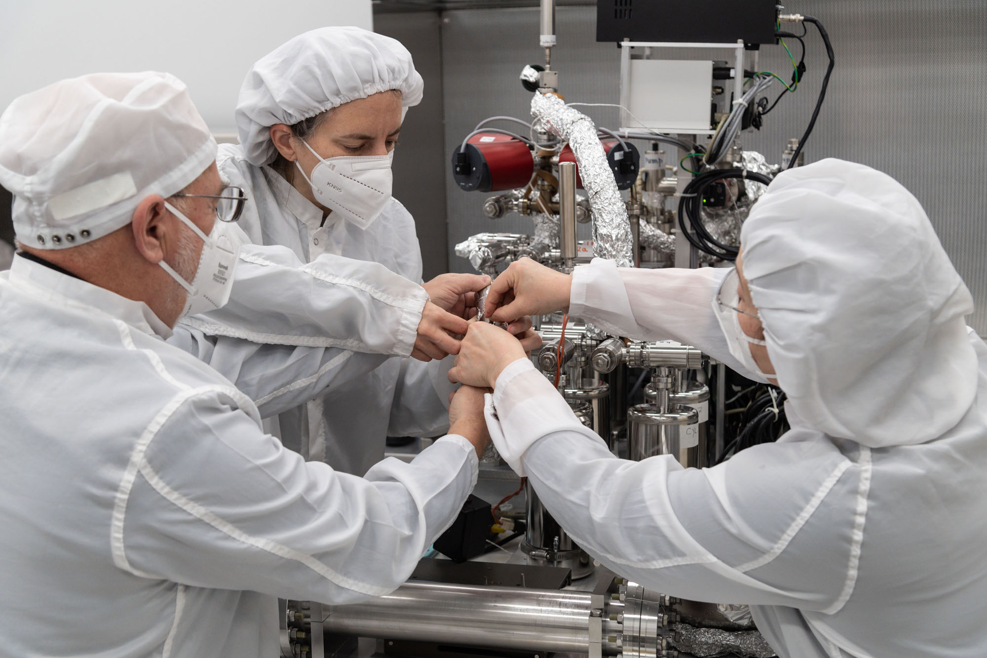 From left, Dr. Juliane Gross, Astromaterials Research and Exploration Science Division (ARES) deputy Apollo curator, alongside Drs. Alex Meshik, and Olga Pravdivtseva, from Washington University in St. Louis, begin a gas extraction process using the manifold to tap into a 1972 moon sample collected by Apollo 17 astronauts.