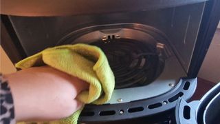 Air fryer heating element being wiped