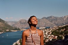 Happy woman enjoying sunlight on face during vacation