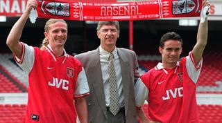 Arsenal football club manager Arsene Wenger (C) with the clubs' new signings, Emmanuel Petit (L) and Marc Overmars 17 June at Highbury Stadium in London. Petit was signed from AS Monaco and Overmars from Ajax. (Photo credit should read ADRIAN DENNIS/AFP via Getty Images)