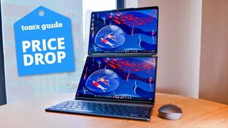 Lenovo Yoga Book 9i on table with Tom's Guide price drop badge