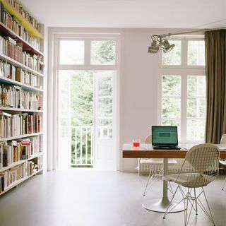 white window with book shelf and wooden table