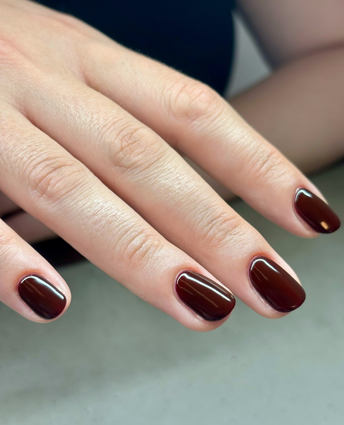 A close-up picture of a maroon manicure