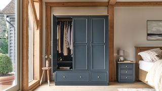 bedroom with dark grey wardrobe and wooden beams