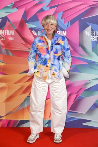 Emma Thompson wearing white jeans and a graphic jacket