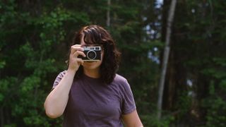 A photographer holds a screen-free digital camera