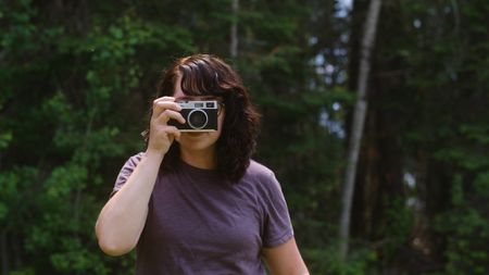 A photographer holds a screen-free digital camera