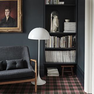 room with white floor lamp grey wall and open book shelve