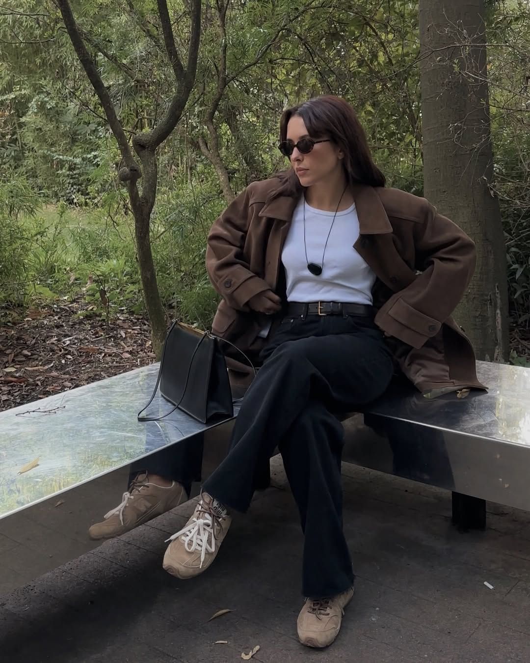 @deborabrosa wears beige Miu Miu X New Balance trainers with black jeans, a white tank top and brown oversized jacket