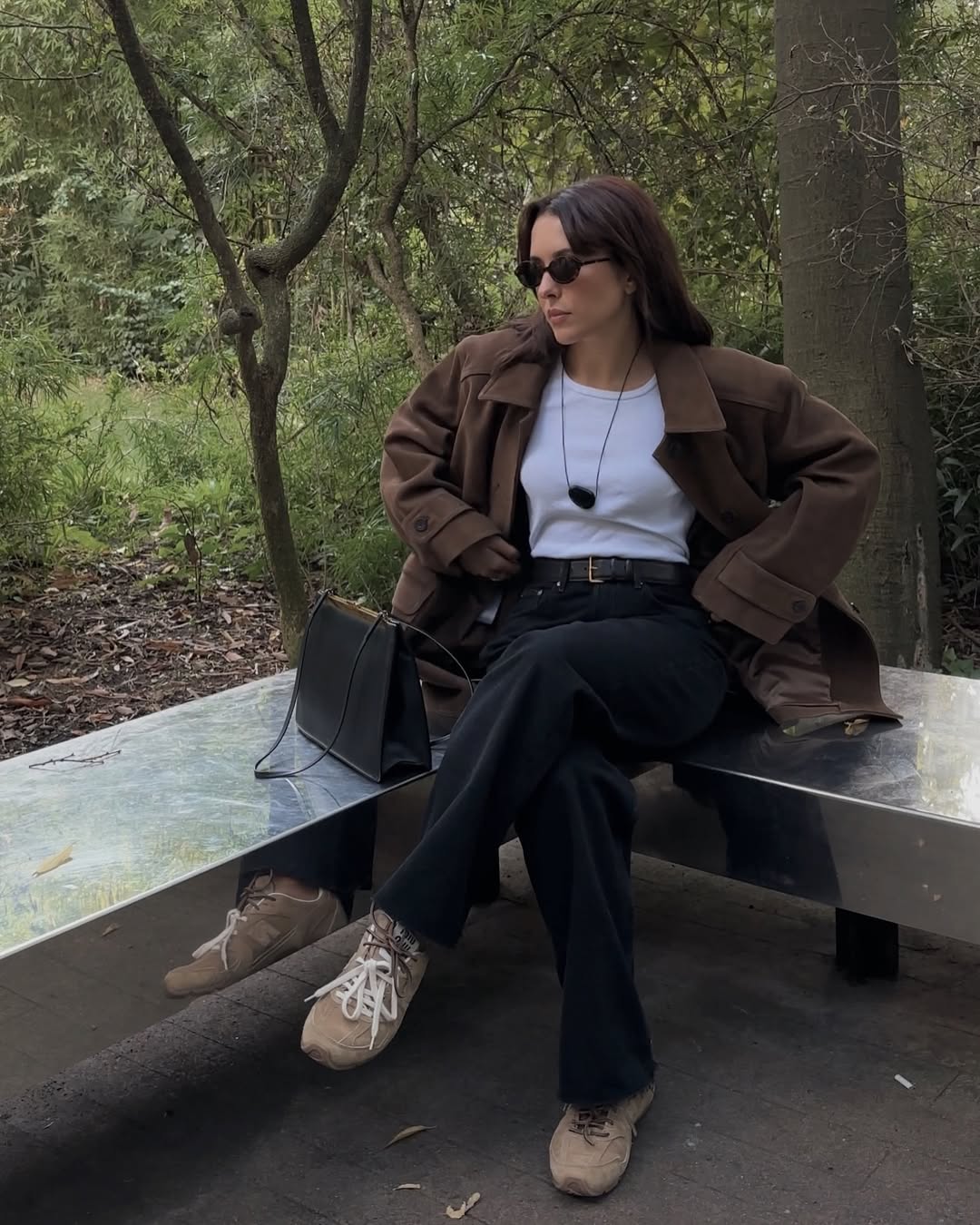@deborabrosa wears beige Miu Miu X New Balance trainers with black jeans, a white tank top and brown oversized jacket
