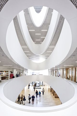 A central oval-shaped atrium dominates the interior, uniting all floors.