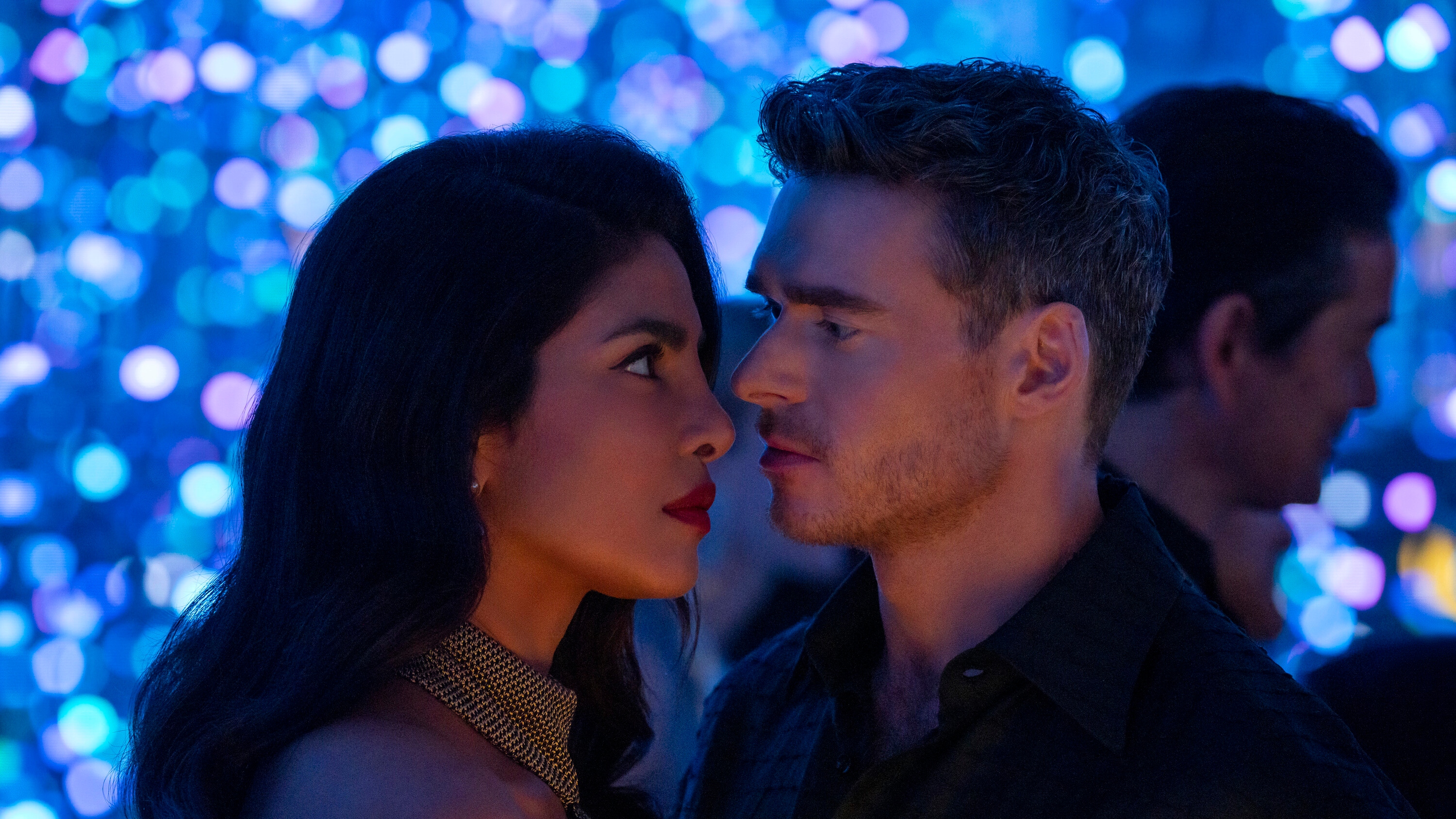 Mason Kane (Richard Madden) and Nadia Sinh (Priyanka Chopra Jonas) with their faces close to each other as they look at one another.