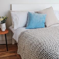 bedroom with flower in white vase and bed with pillows