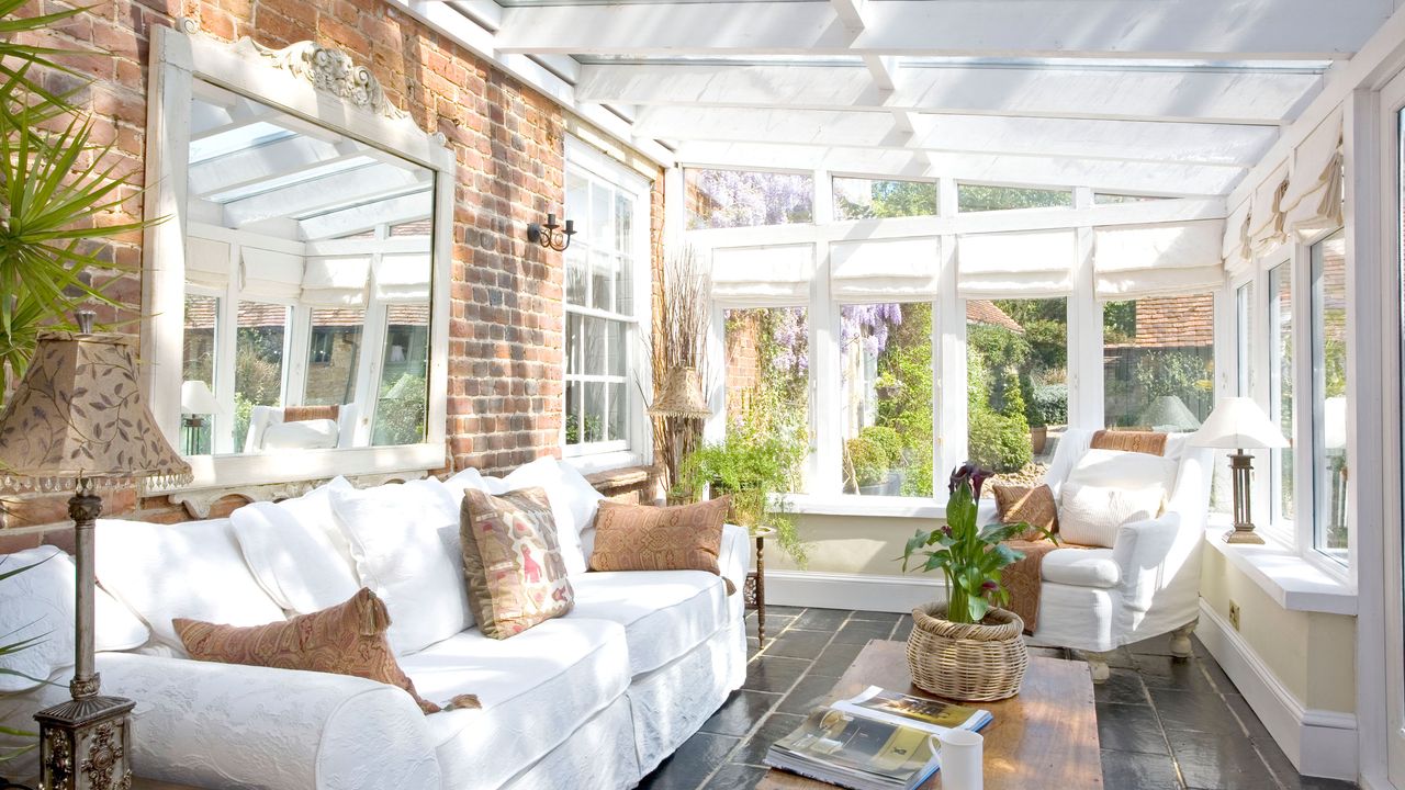 Conservatory with exposed brick walls and large white sofa 