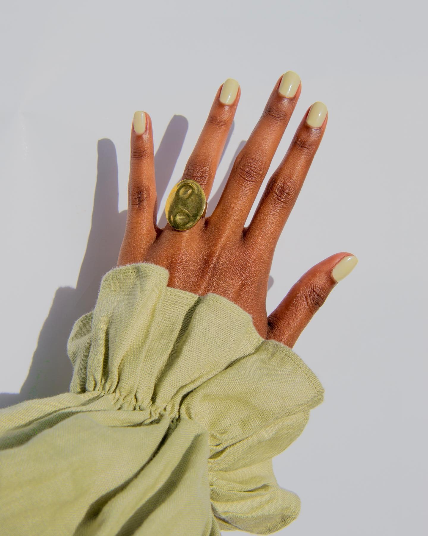 Person wearing light green jelly nail polish.