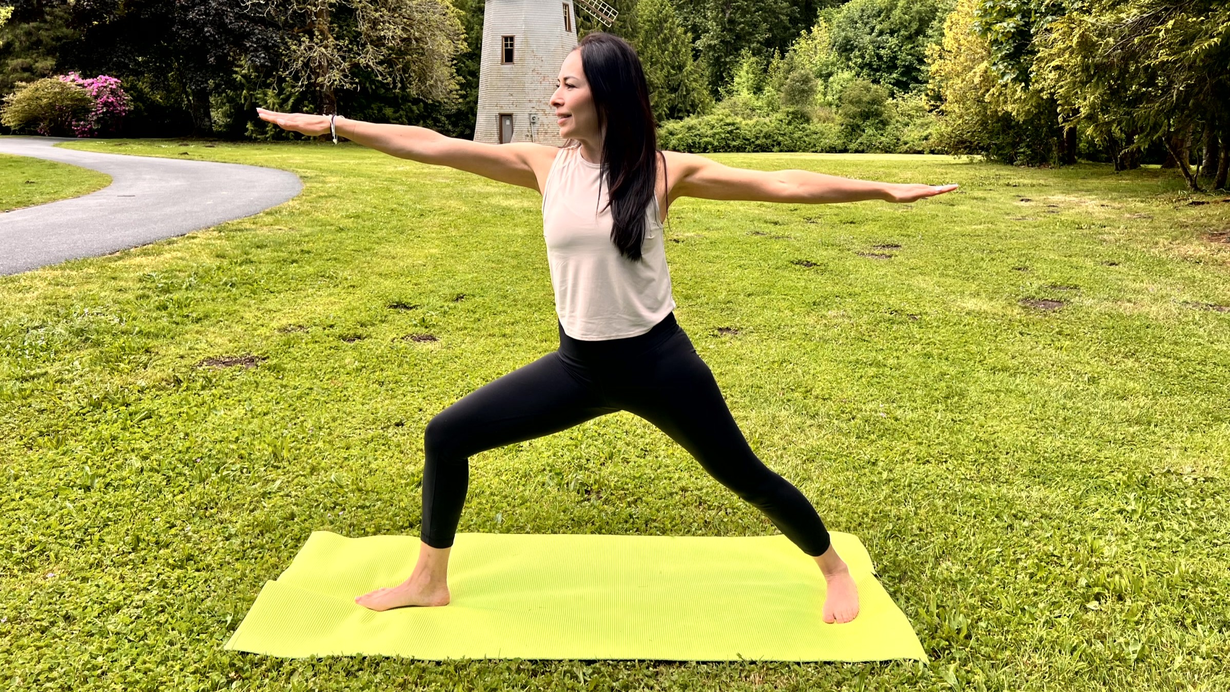 Woman in yoga pose on a mat in her garden