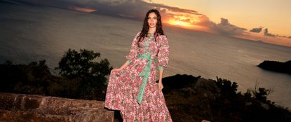model wearing a colourufl dress in front of a sunset 
