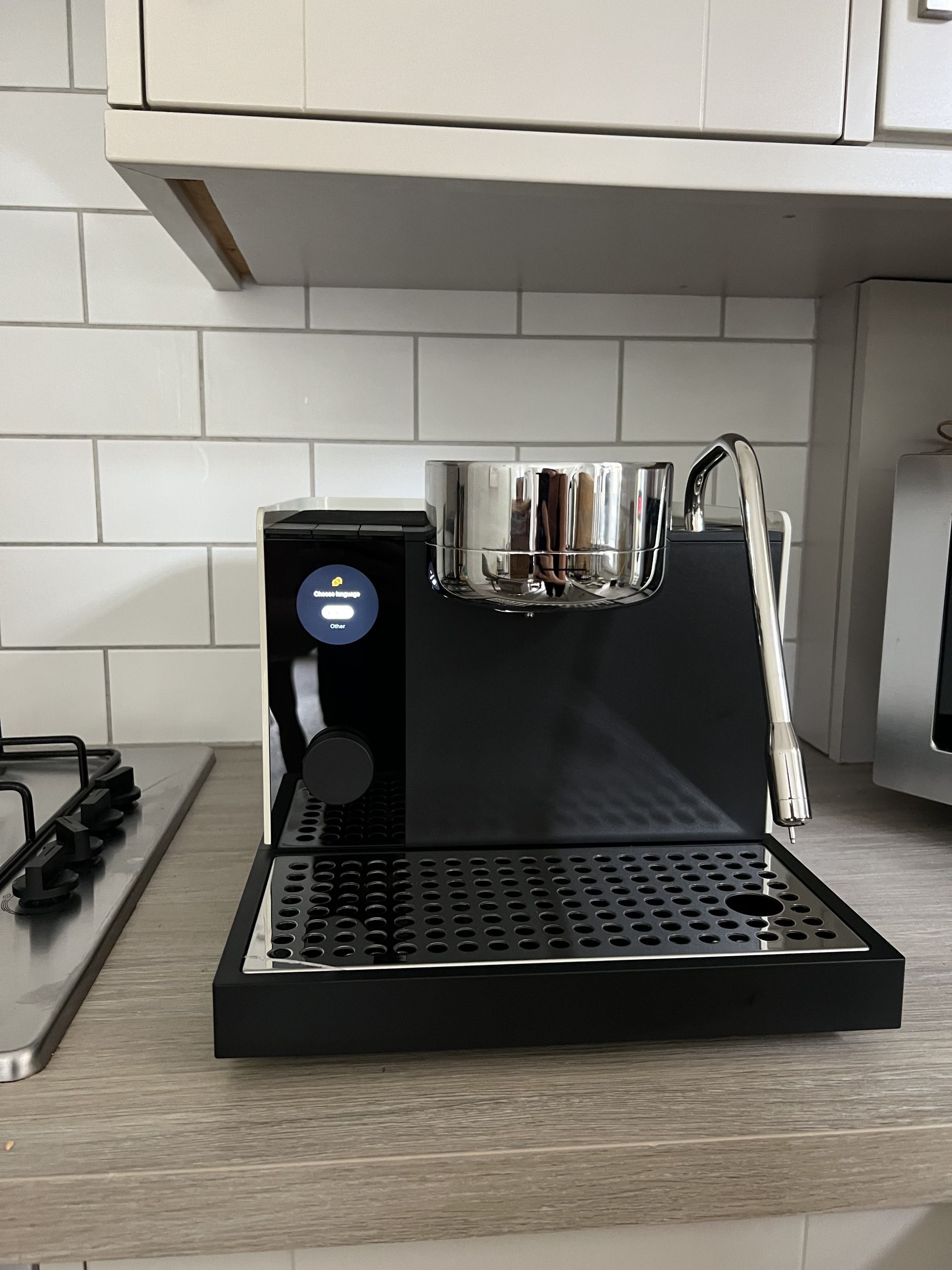 Image of the Fellow Series 1 Espresso Machine on a light wood countertop in a white kitchen.