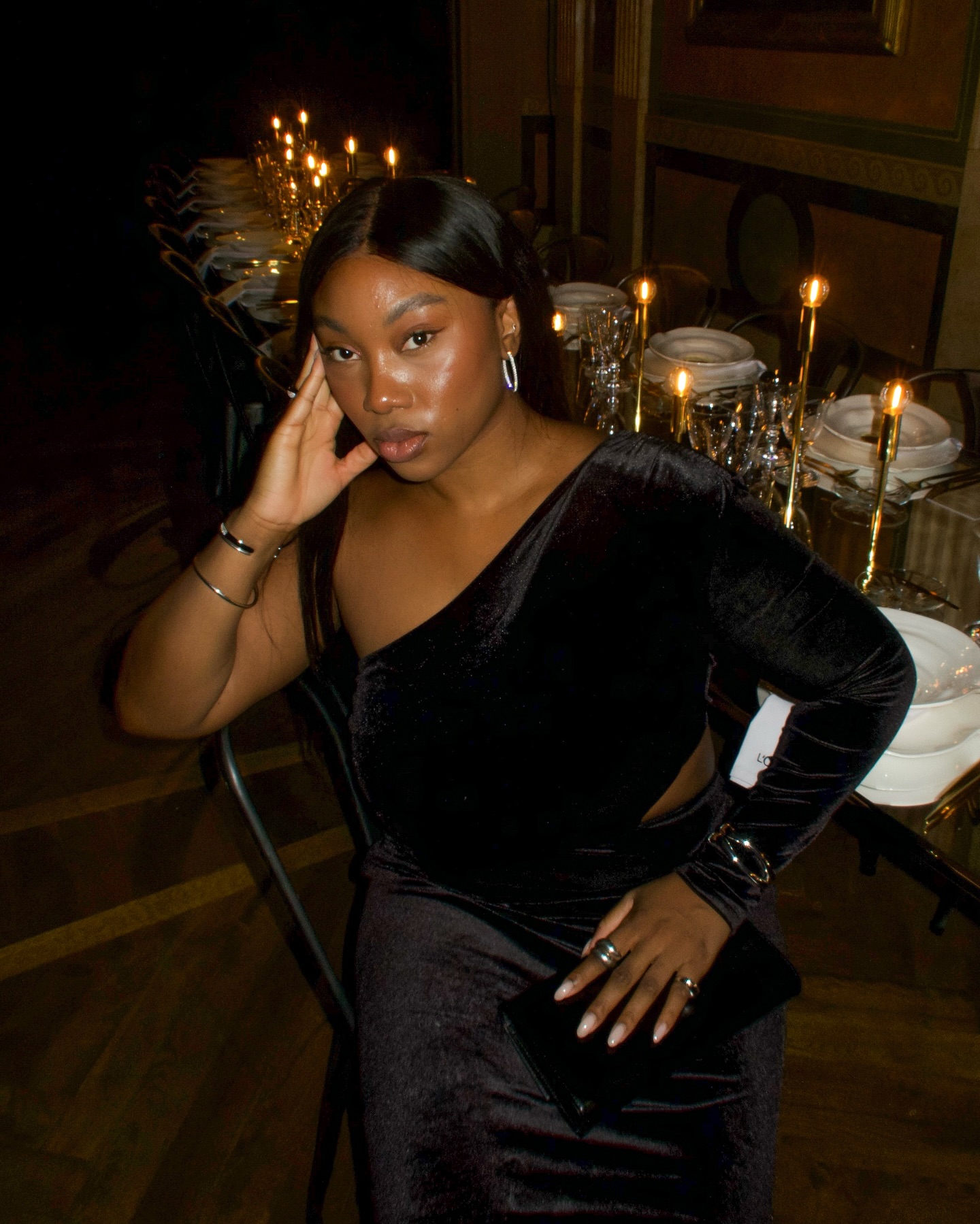 An image of @nnennaechem wearing a velvet one-shoulder dress, an example of an autumn wedding guest outfit.