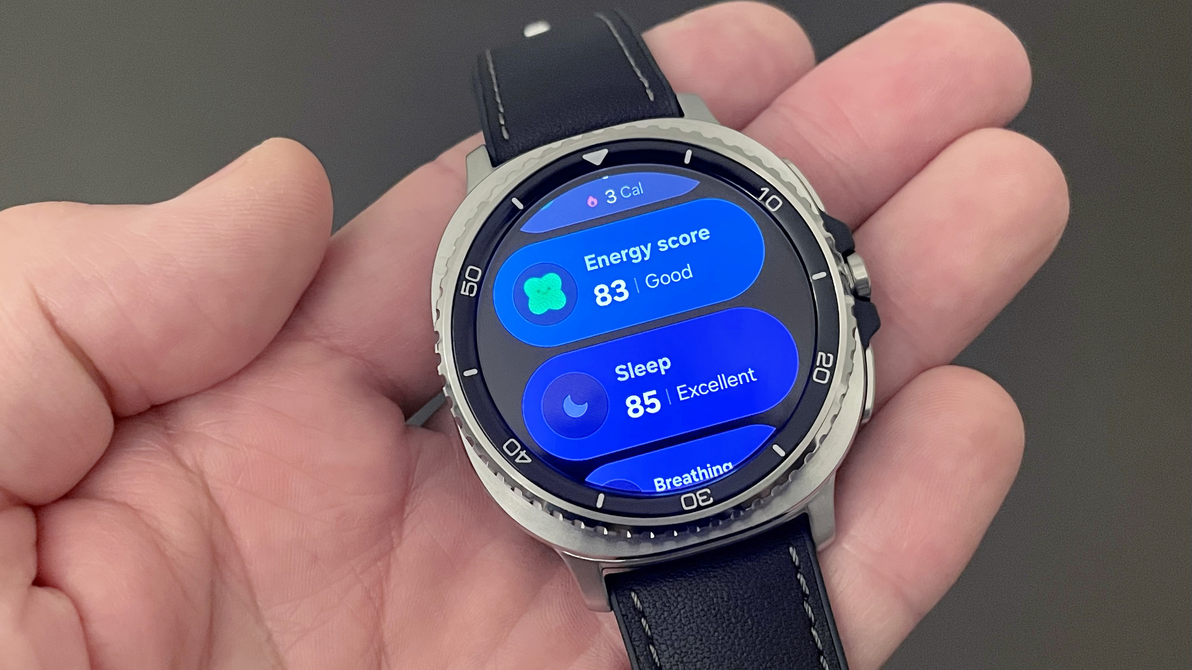 Close-up of the Samsung Galaxy Watch 8 Classic in silver on a black strap showing a user's Energy and Sleep Scores