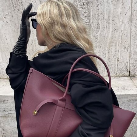 a woman wearing a shoulder bag and coat