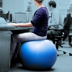 Woman sitting at her desk on a yoga ball.