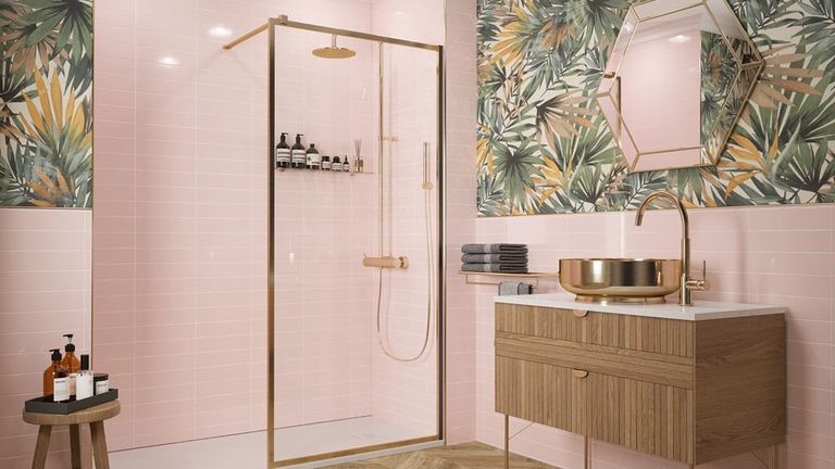 a bathroom with one wall made up of pastel green wall tiles laid horizontally, another wall made up of mostly pink wall tiles laid veritcally with grey wall tiles laid horizontally underneath, and a freestanding white bathtub in front of the wall