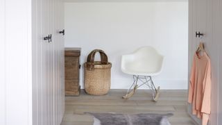 small bedroom organisation ideas with basket for clothes and a white rocking chair