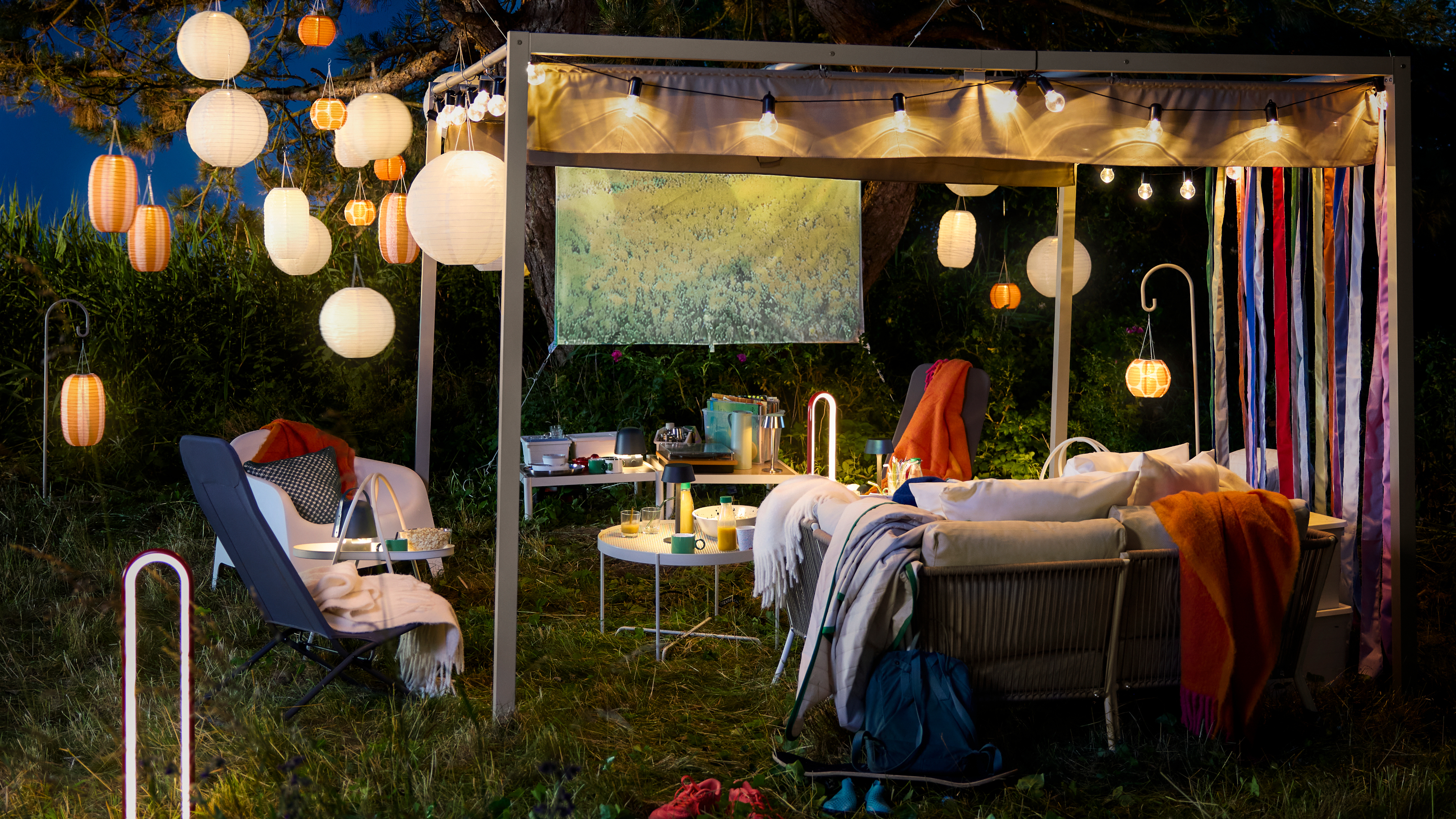 ikea pergola in the evening with solar lanterns and outdoor furniture