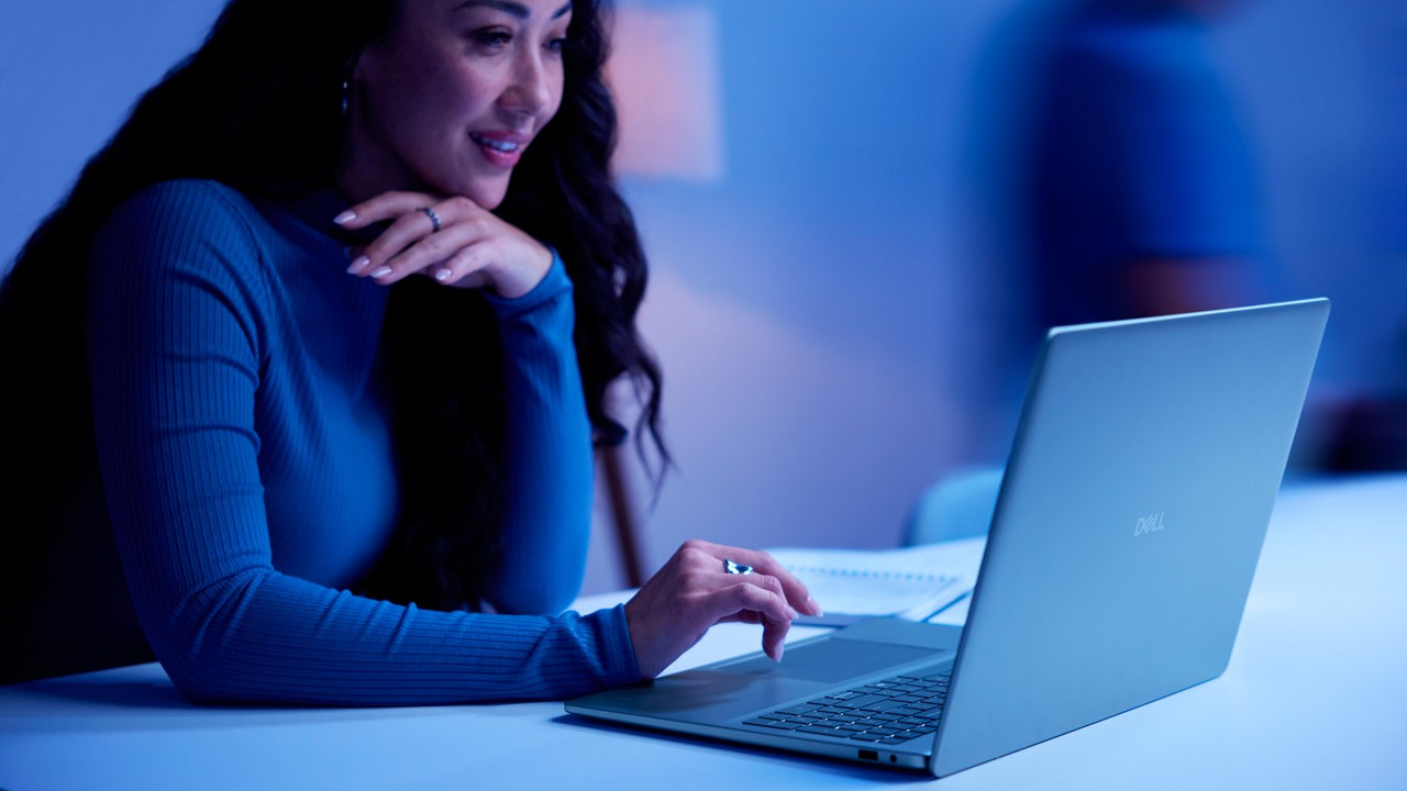 Dell Plus Laptop on a desk with a person working on it