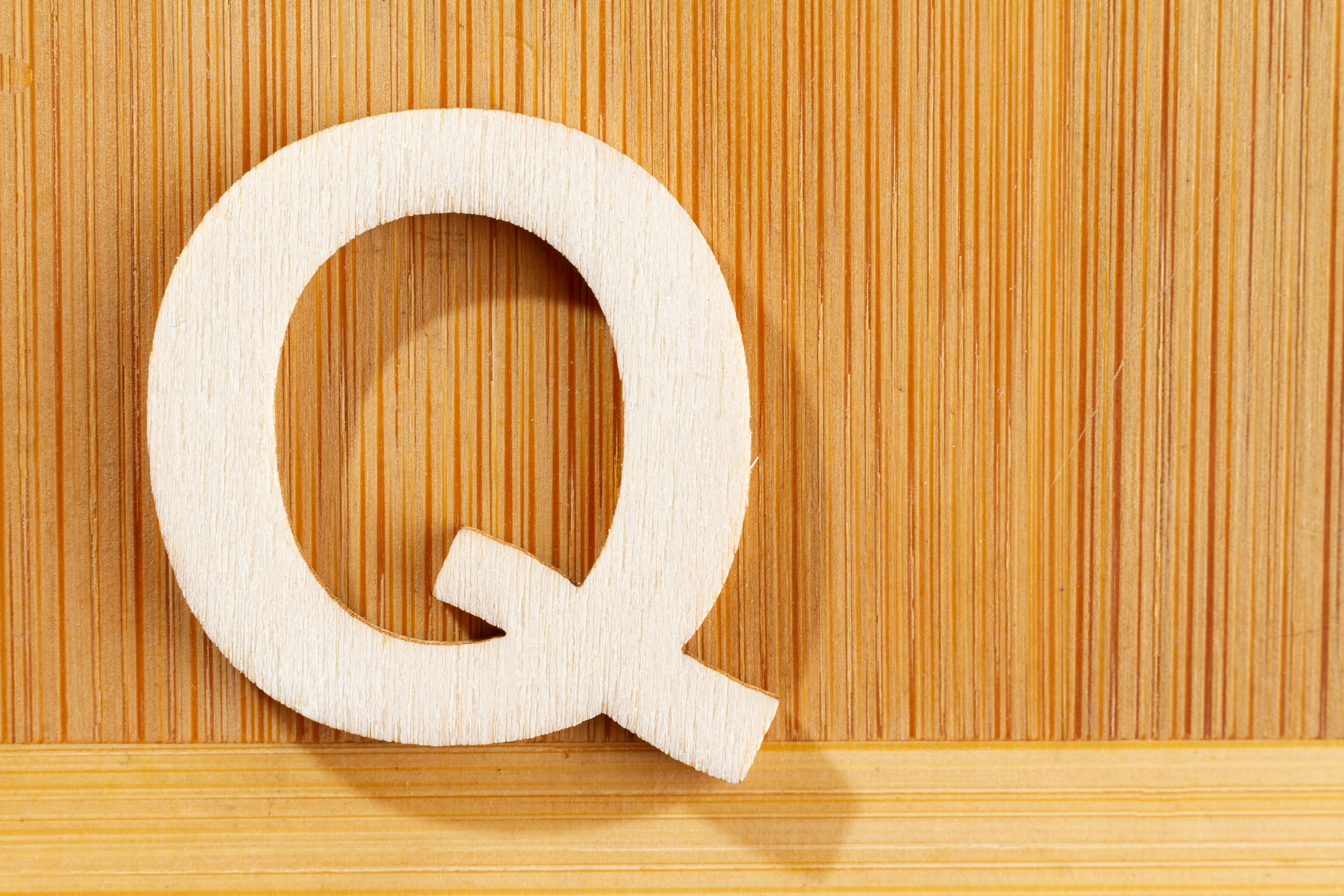 wooden letter &quot;Q&quot; on a wood background