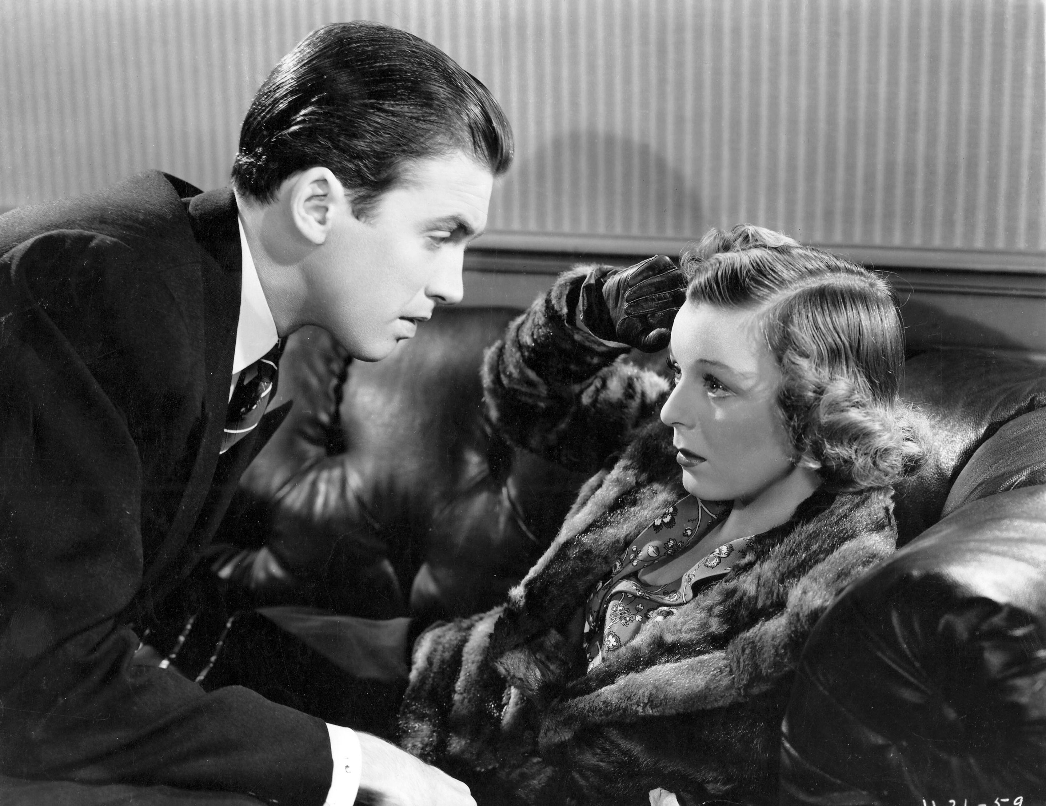 james stewart and margaret sullivan talking to each other a couch in a still from the movie shop around the corner