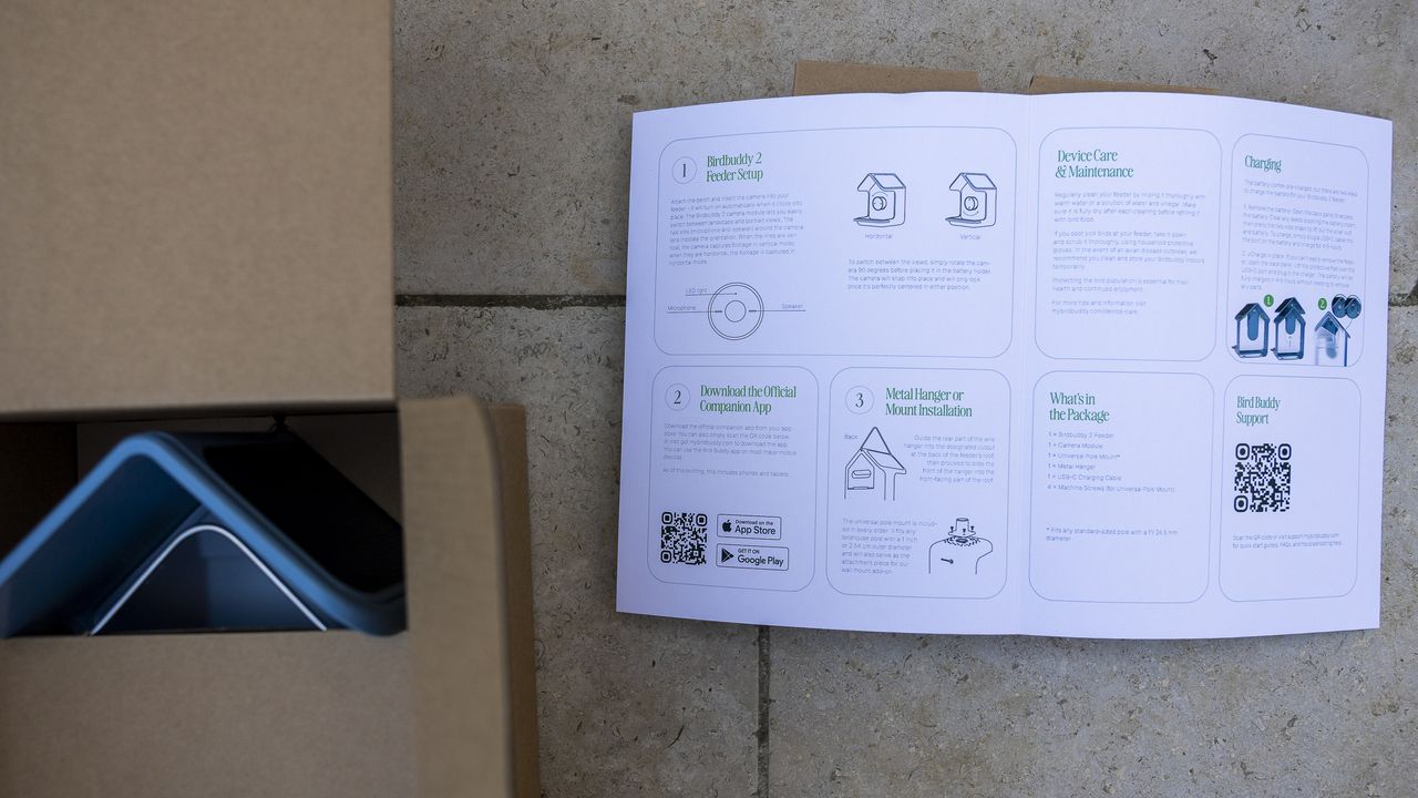 The instruction manual for Bird Buddy 2 laid open on a patio