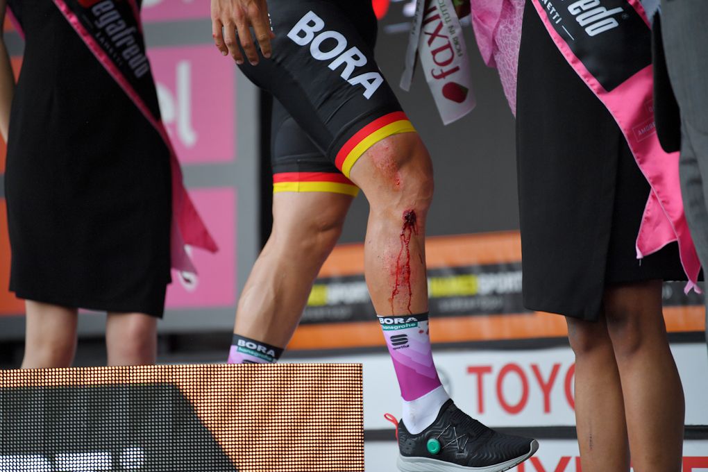 Pascal Ackermann (Bora-Hansgrohe) on the Giro podium to accept the sprinter's jersey after crashing during stage 10