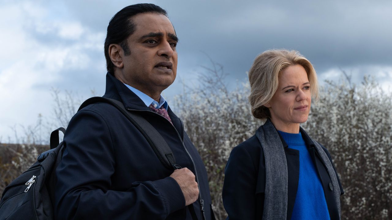 SANJEEV BHASKAR as DI Sunny Khan and SINEAD KEENAN as DCI Jess James stand at Whitney Marsh in Unforgotten season 6