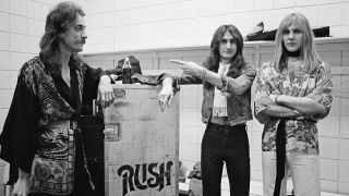 Neil Peart, Geddy Lee and Alex Lifeson from Rush pose backstage in Springfield, Massachusetts, 9th December 1976 during their All The World's a Stage tour. (Photo by Fin Costello/Redferns)
