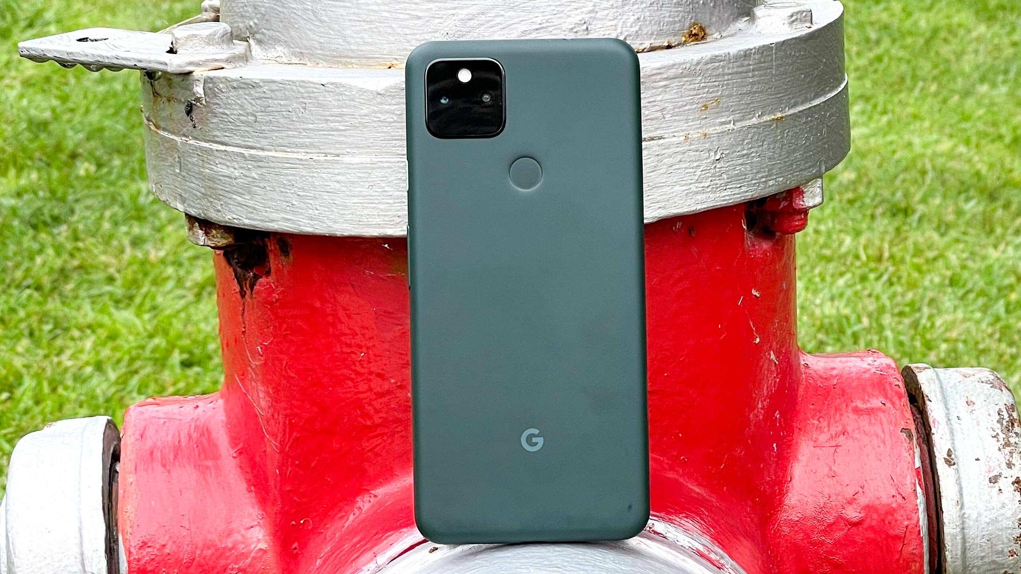 Google Pixel 5a resting against a metal pipe