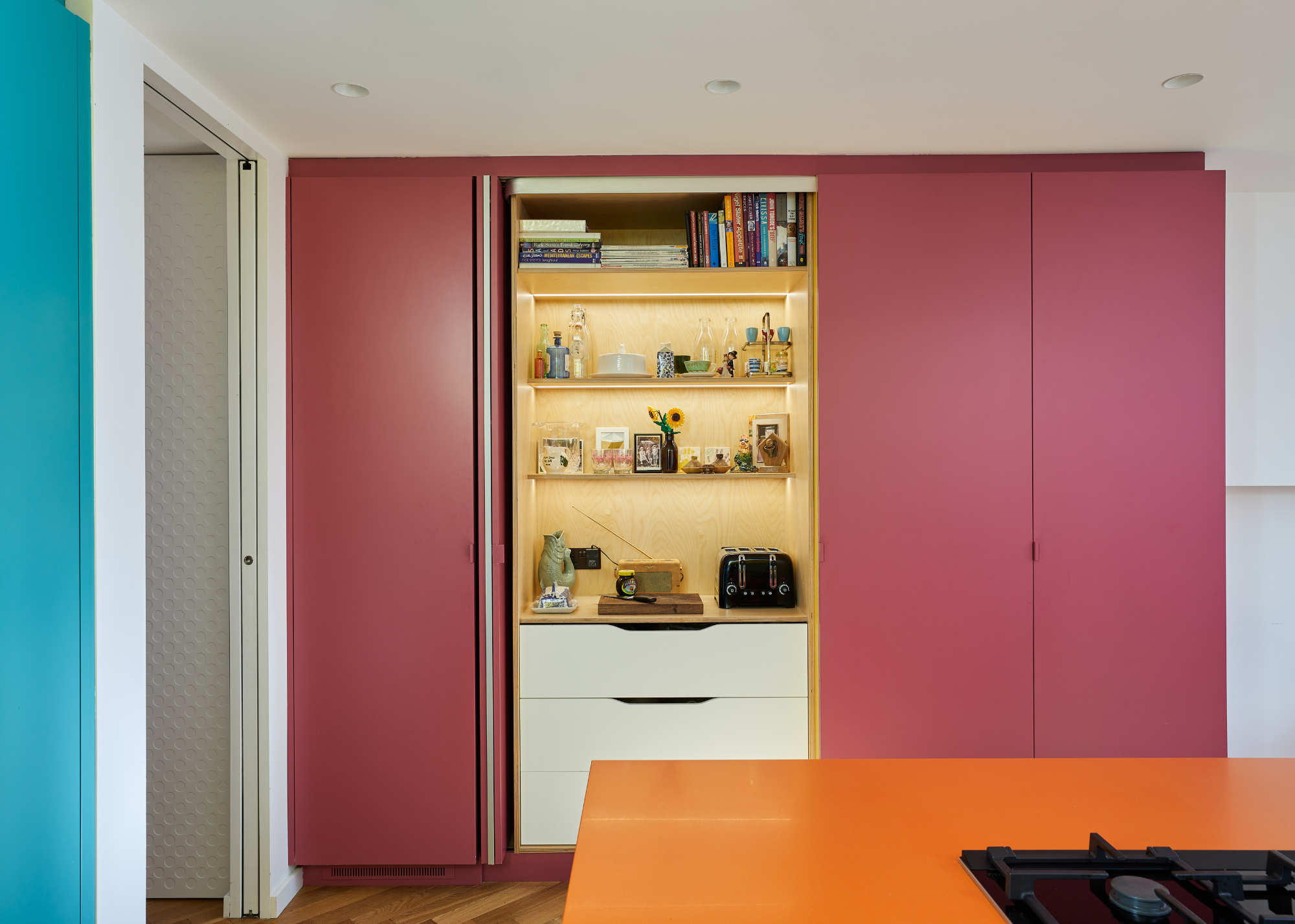 pink HIMAC kitchen cabinets with a pocket door breakfast bar