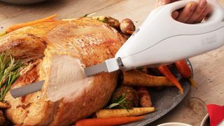 A Russell Hobbs electric carving knife being used on chicken