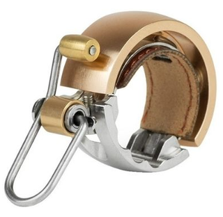 A rose gold Knog Oi Bell against a white background 